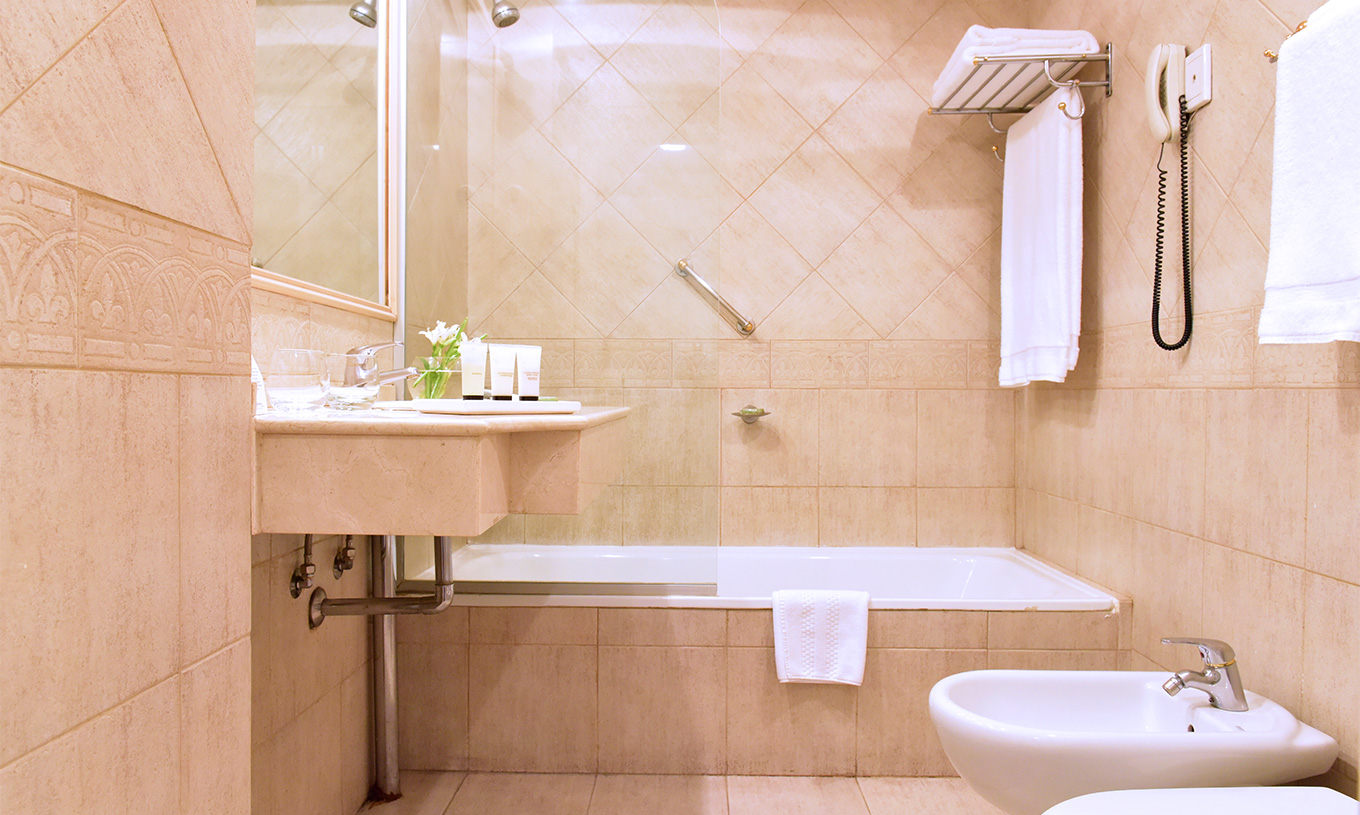 The Twin Deluxe Room at Pestana Buenos Aires has a bathroom with a sink, mirror, and a bathtub with a shower