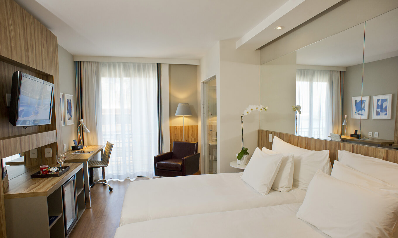 The Twin Side Sea View of Pestana Rio Atlântica has two beds with a mirror on the headboard and a television in front