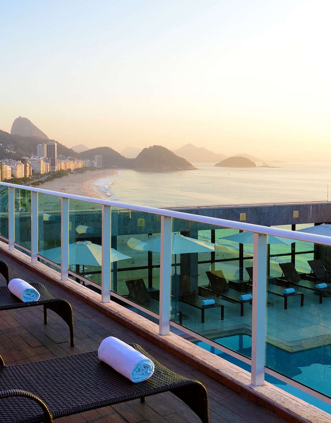 Rooftop of a 4-star hotel in Rio de Janeiro, with sun loungers with towels and a view of Copacabana Beach