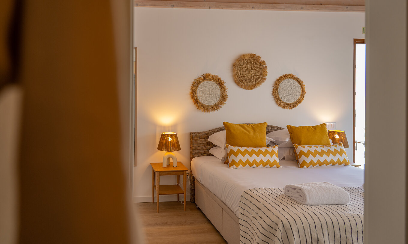The Superior Villa at Pestana Comporta Village Residences has a bedroom with a double bed and yellow pillows