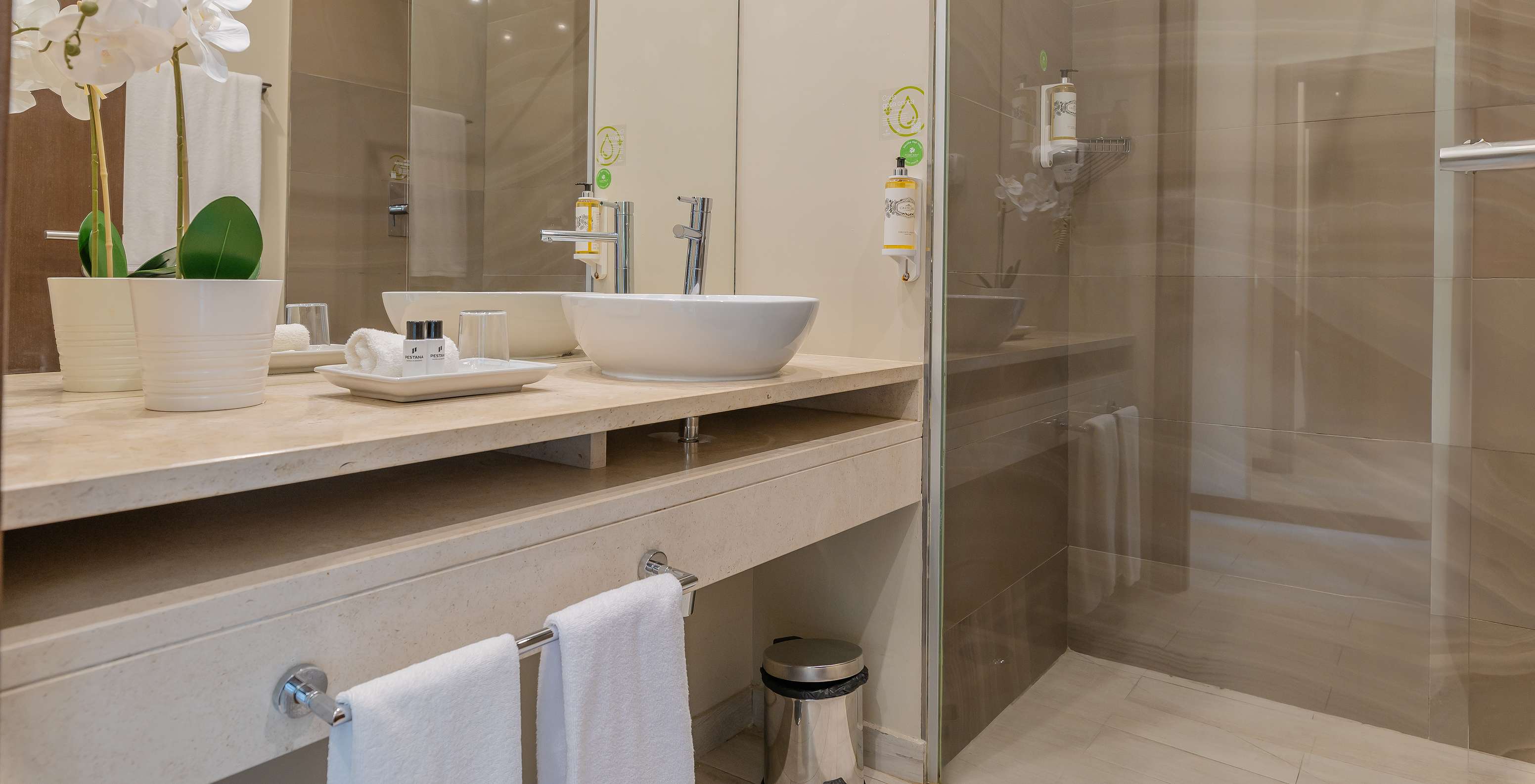 The Garden Suite at Pestana Alvor Park has a bathroom with a bathtub and a sink with a flower vase