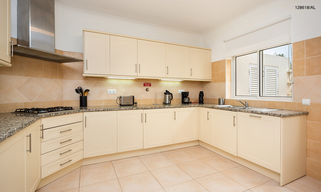 The Pestana Carvoeiro Golf V3 Superior Villa has a kitchen equipped with white cabinets and appliances