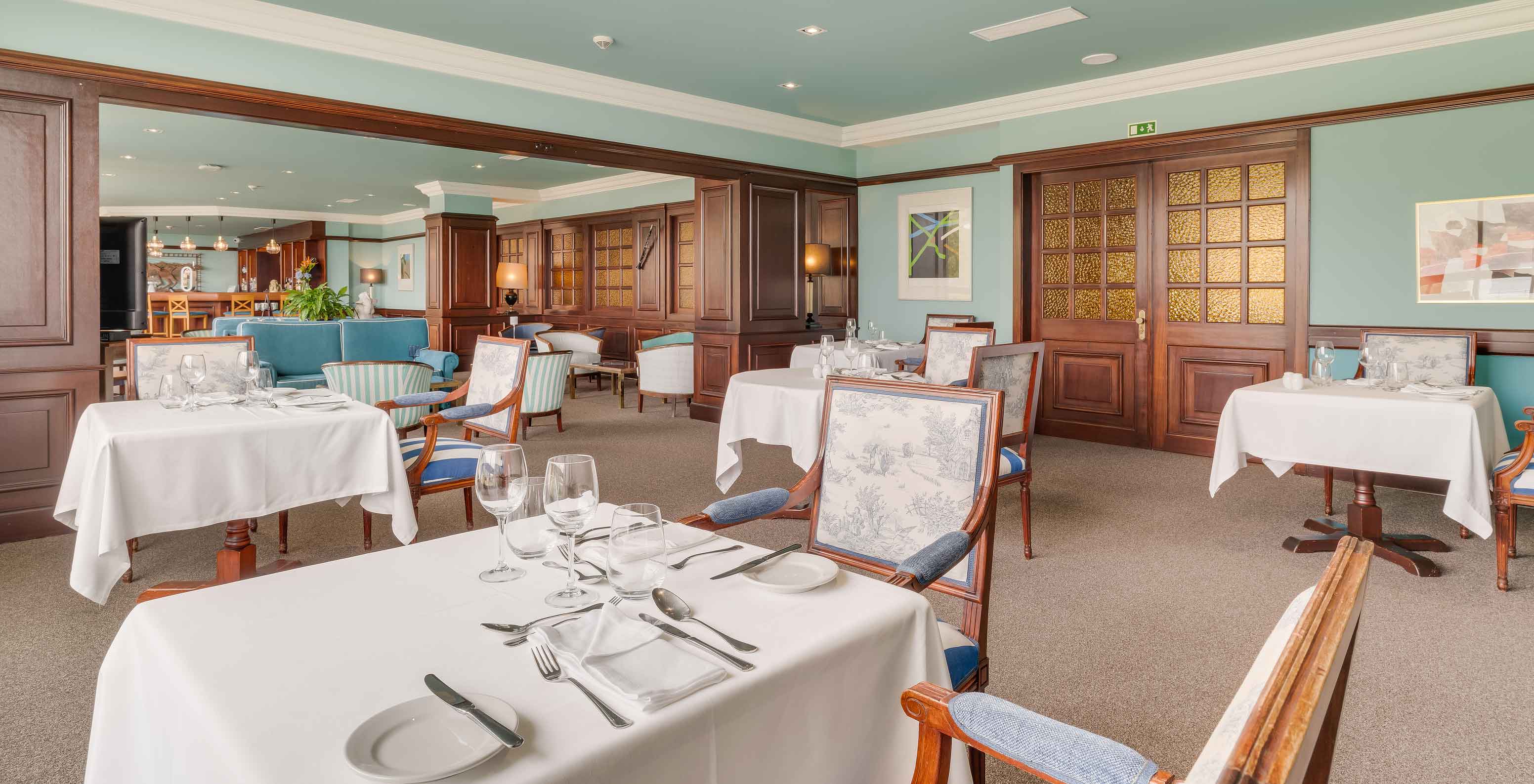 Interior of Bar Aqqua at Pestana Bahia Praia with set tables, classic chairs, and cozy atmosphere