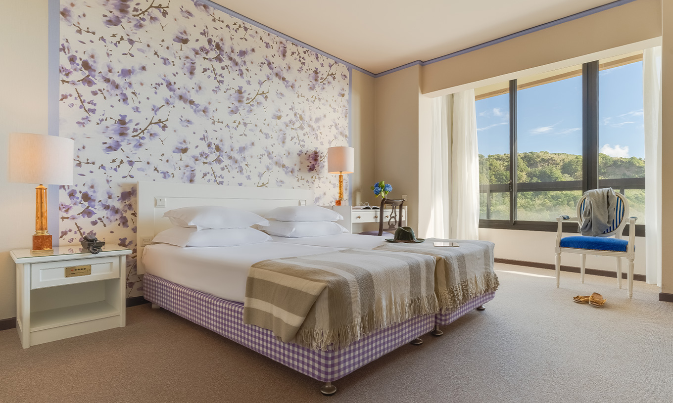 Standard Garden View room at Pestana Bahia Praia is a spacious room with two beds, a bedside table and a desk