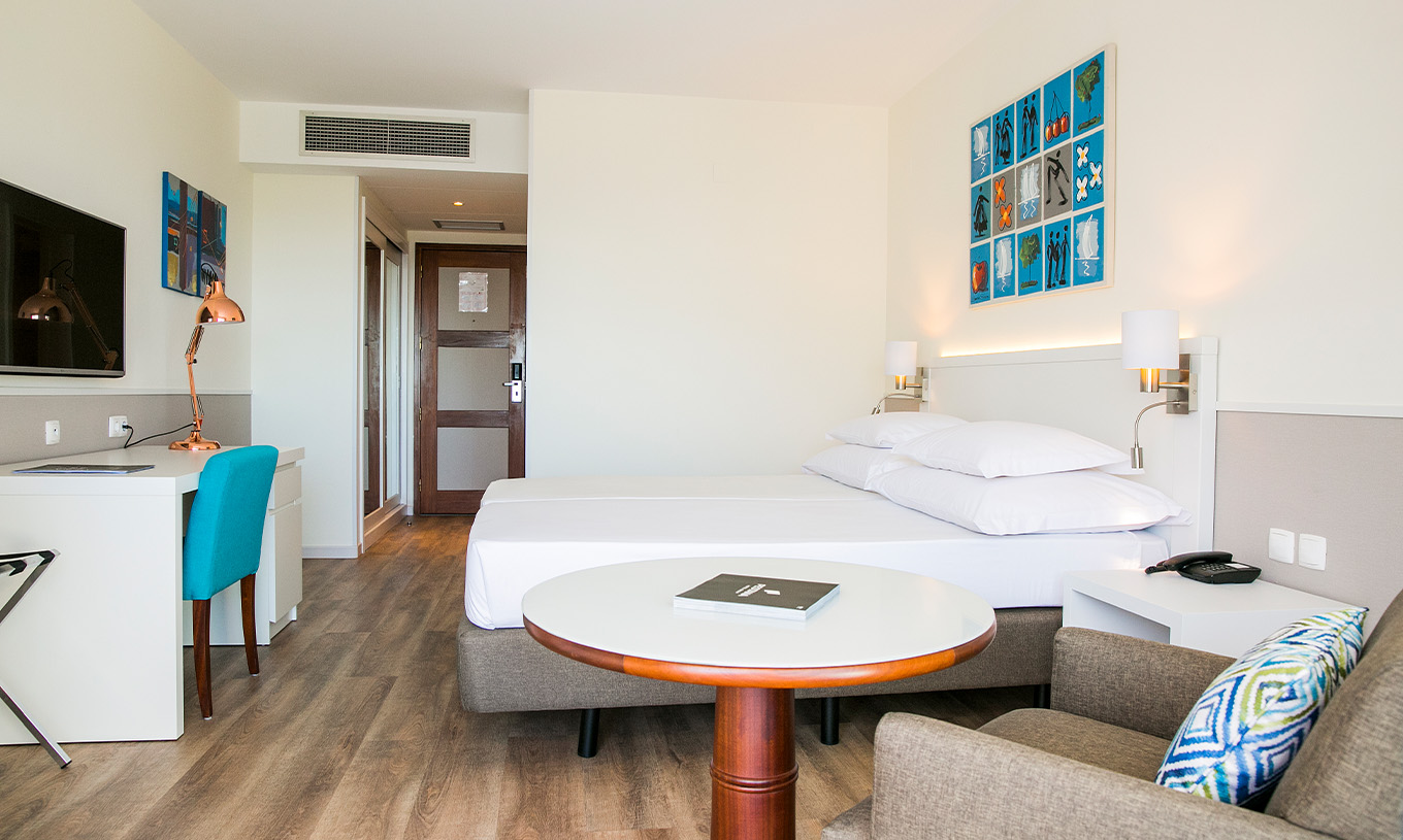 The Superior Deluxe room at Pestana Cascais has two single beds, a TV, a desk, and a kitchen