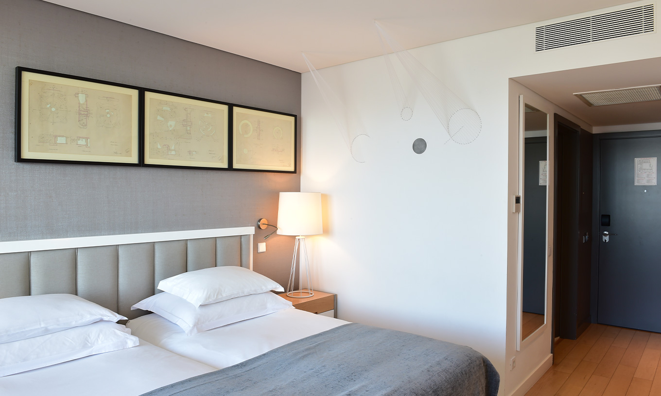 The Double Room Art District at Pestana Cidadela Cascais has two single beds, two paintings, and an art wall