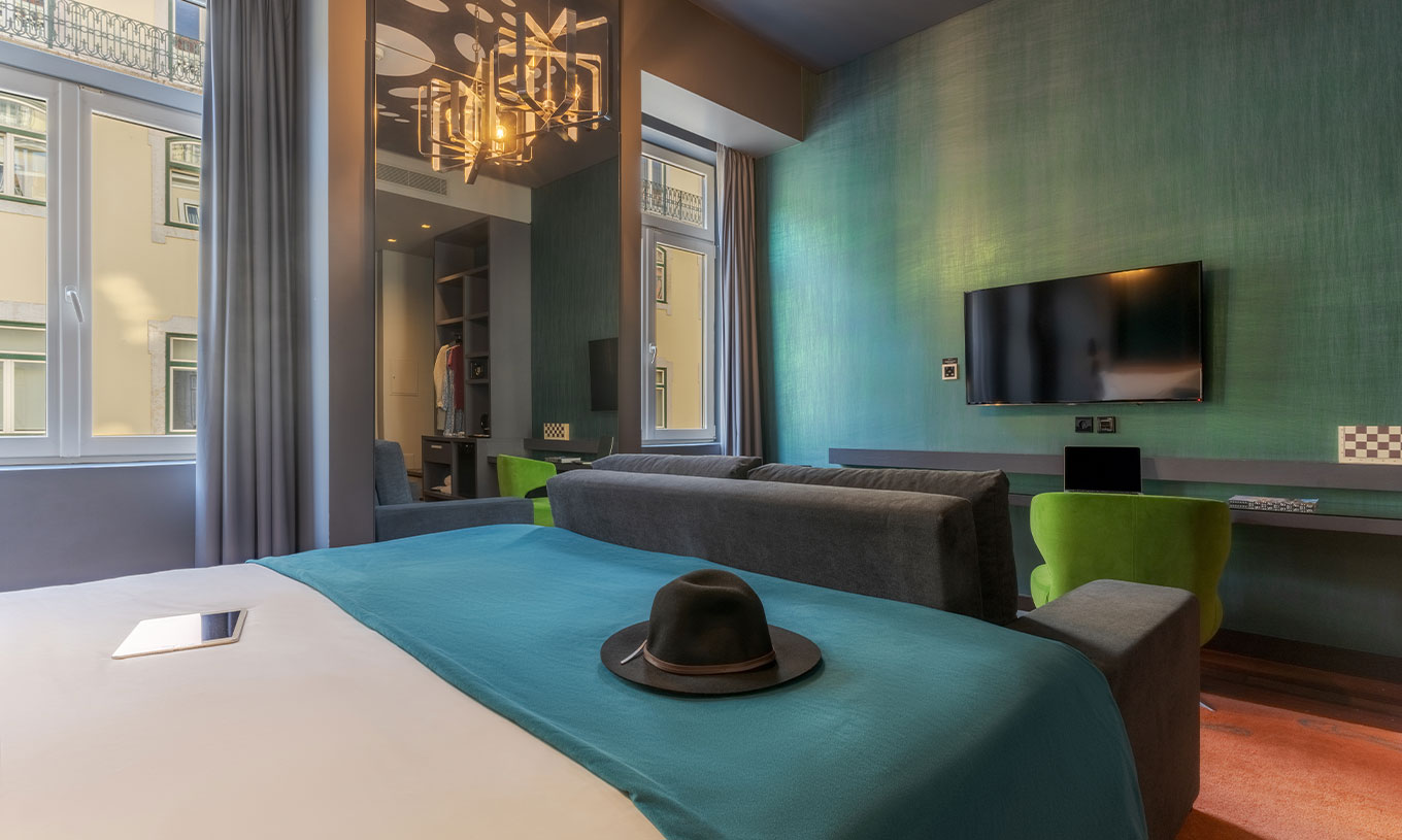 The CR7 Family Hat-Trick Room at Pestana CR7 Lisboa has a mirror, a sofa with television, and a bed