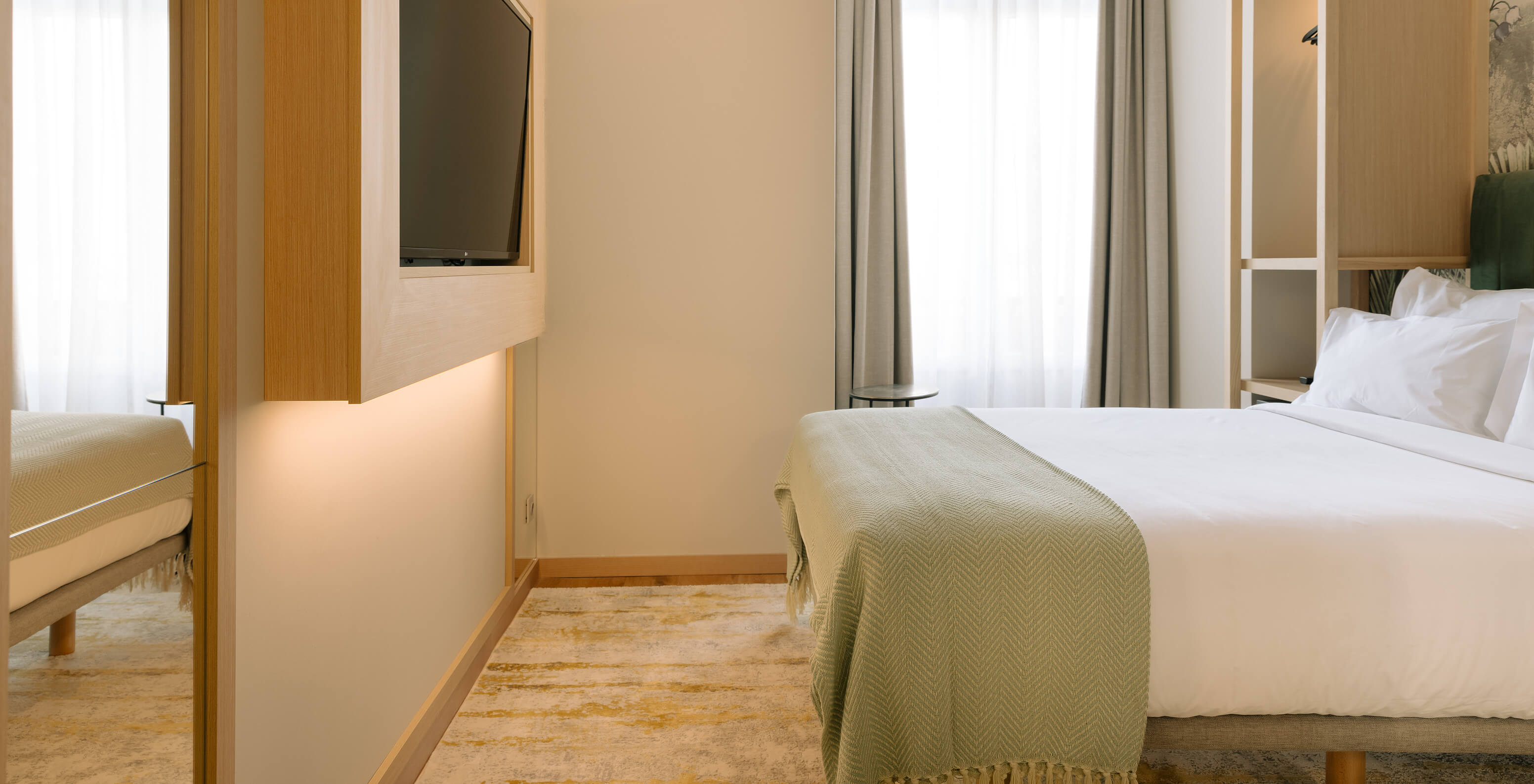 The Cozy Room at the Pestana Rua Augusta Lisbon has a double bed, TV and a window with curtains