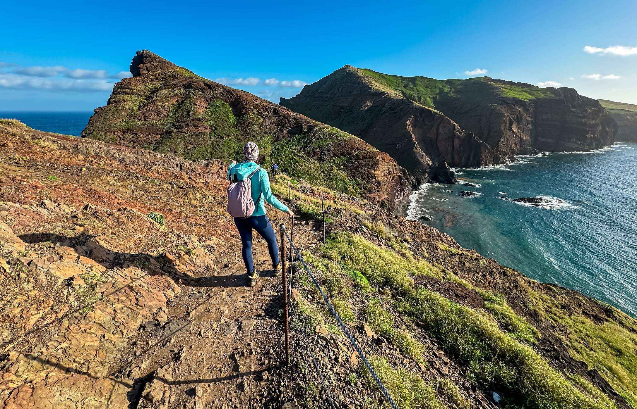 Lady hiking in Funchal, with a view of the mountain and the Atlantic Ocean