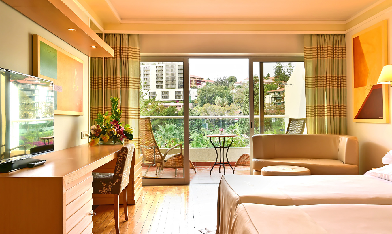 The Classic Double Room with Pool View at Pestana Carlton Madeira has a double bed, a desk, and a balcony