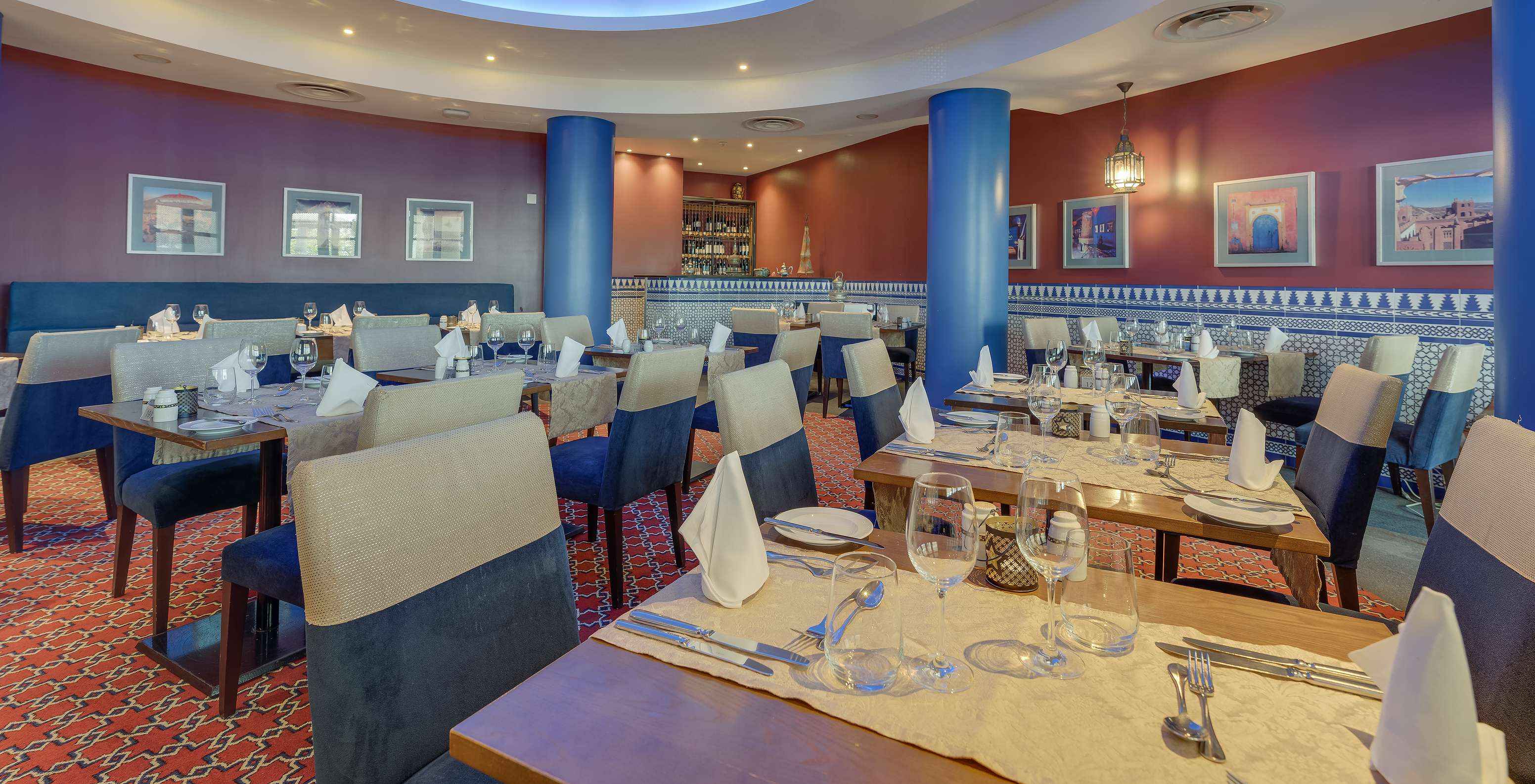 The Au Tagine restaurant at the 5-Star Hotel in Funchal, Madeira, has a table with four chairs and wall art