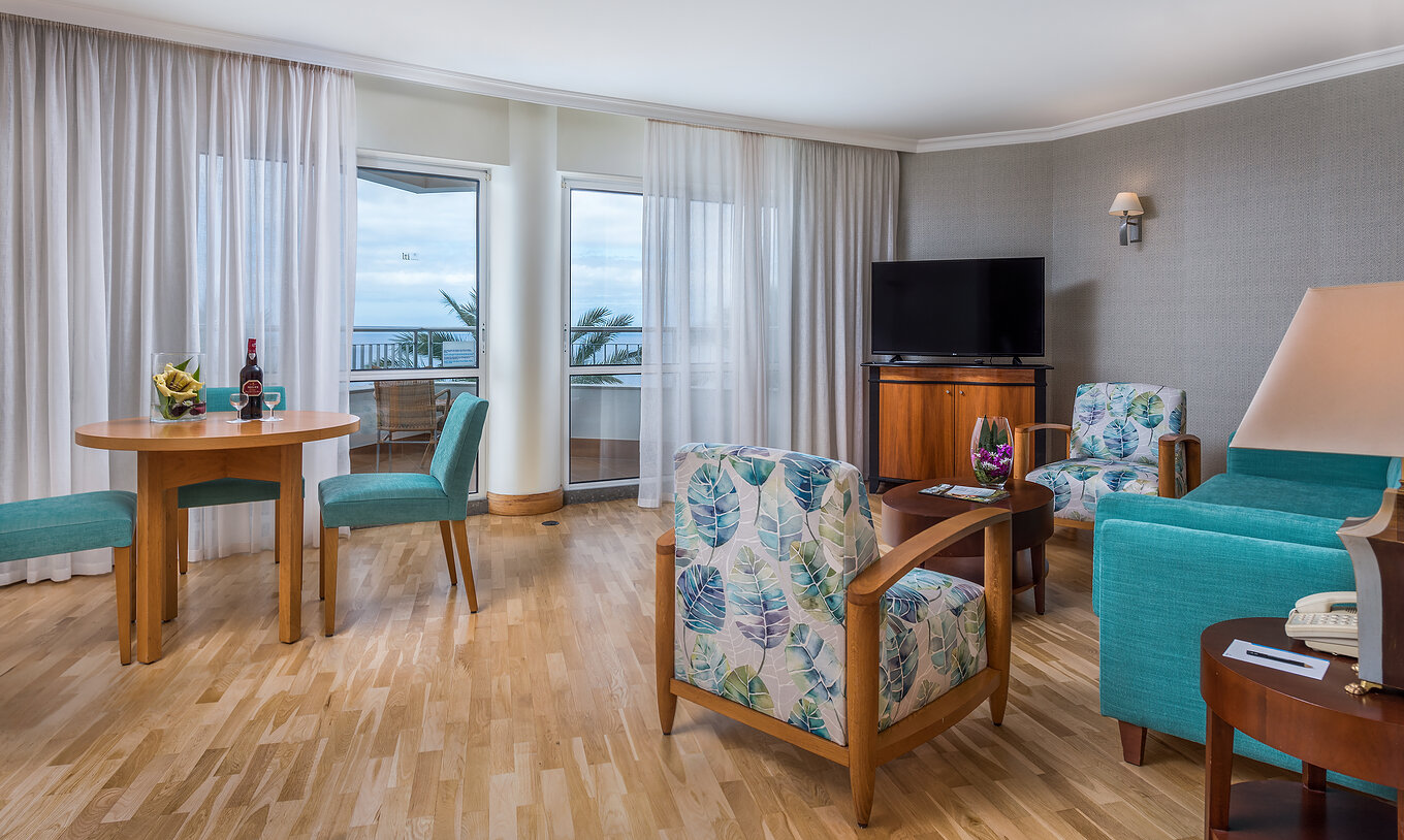 The Standard Suite Sea View at Pestana Grand has a living room, with small dining table and TV