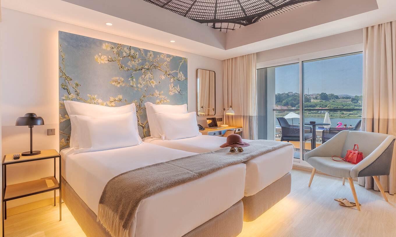 The River View room at Pestana Douro Riverside has two single beds, a bedside table, and a desk with a lamp