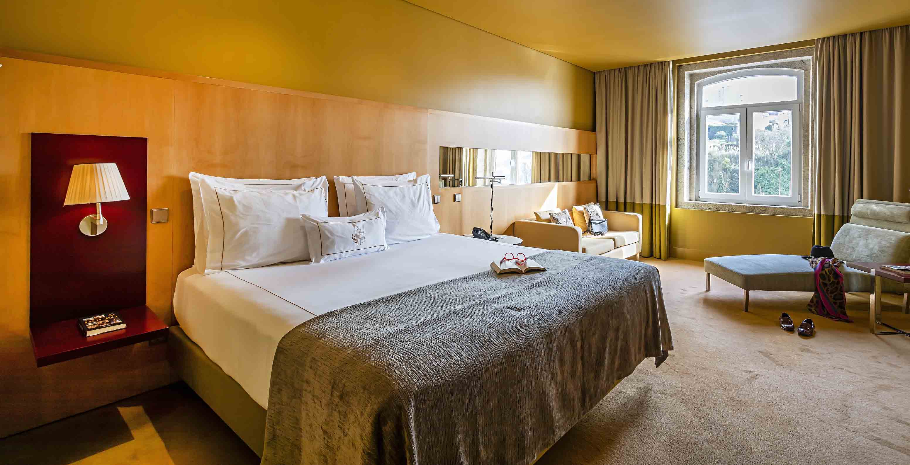 Pestana Palácio do Freixo’s Superior room has a double bed with grey cover and a window with view
