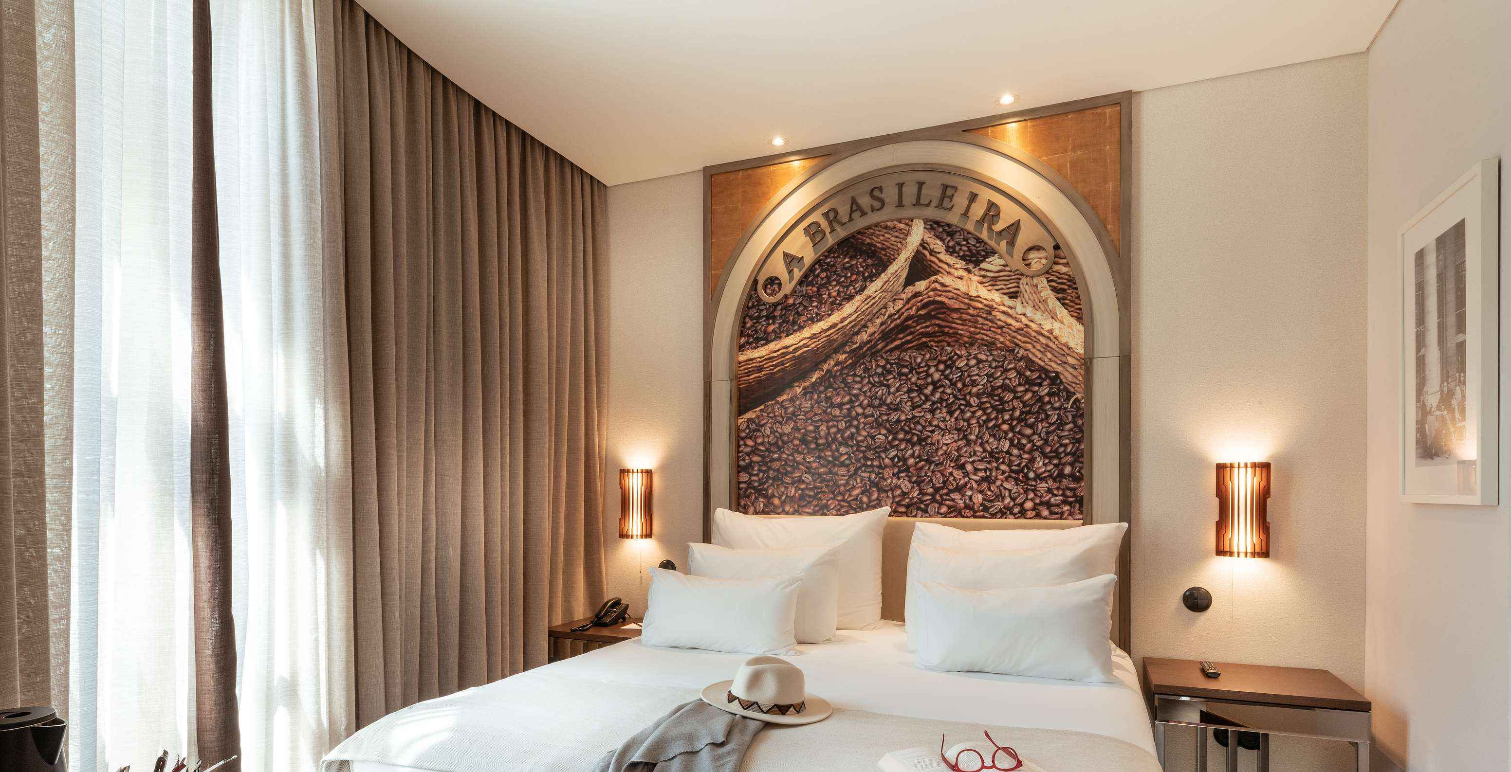 The Deluxe do Pestana Porto - A Brasileira has a double bed with a themed mural on the headboard