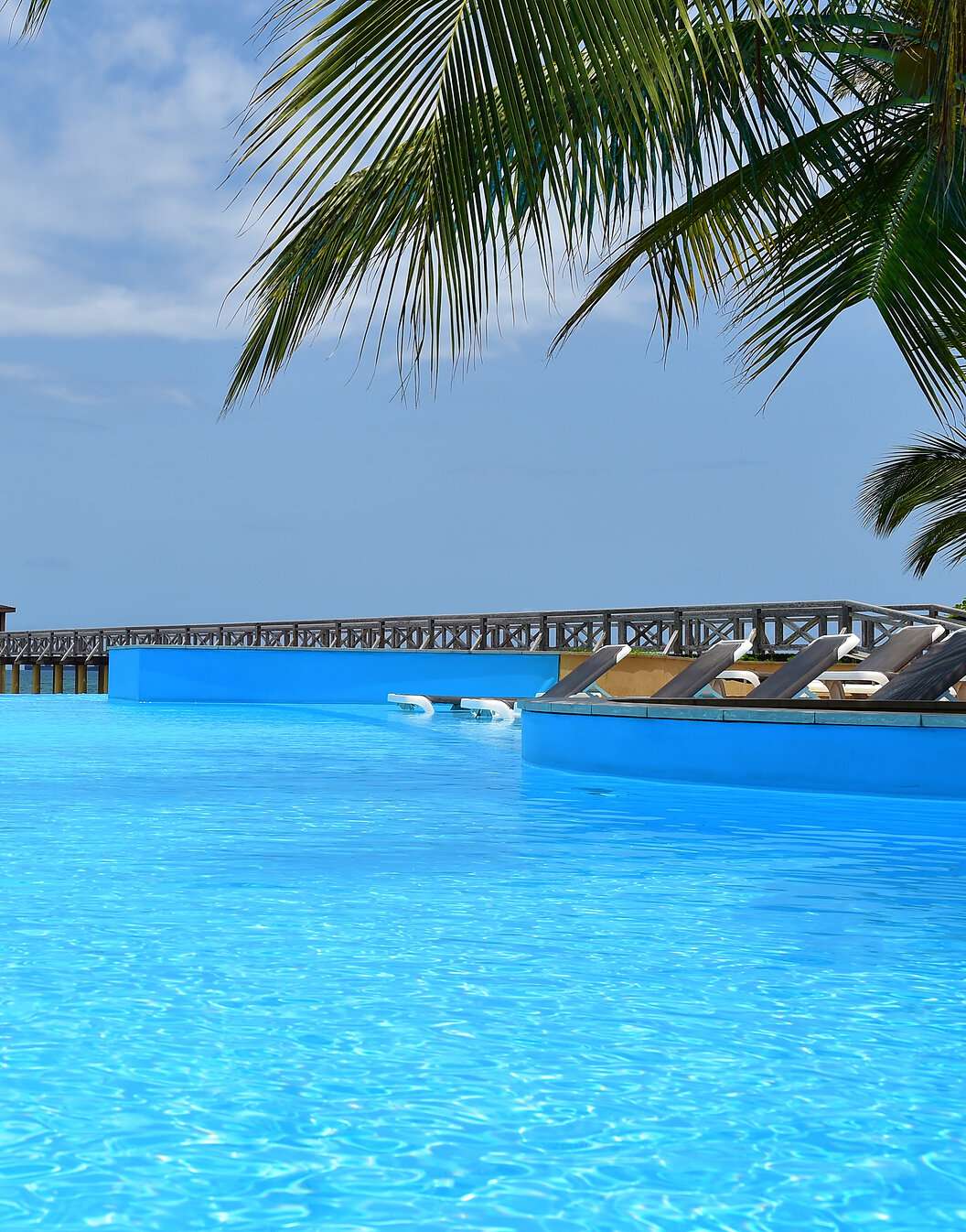 Paradise view of the pool at Pestana São Tomé merging with the crystal-clear sea, an idyllic tropical setting