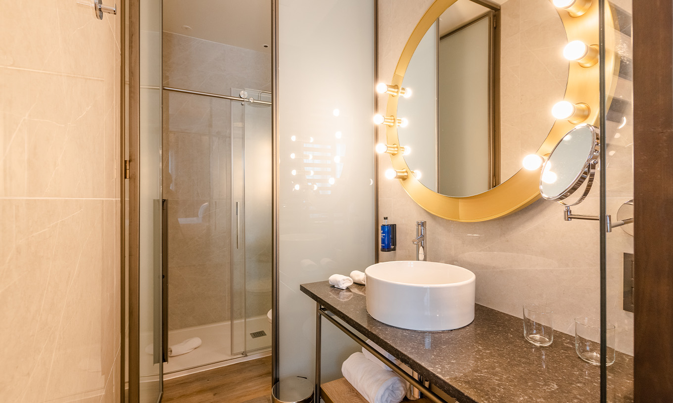 The Premium Room with View at Pestana CR7 Gran Vía Madrid features a bathroom with a round mirror and sliding shower doors