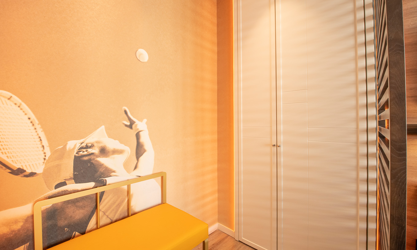 The Legend Room at Pestana CR7 Gran Vía Madrid includes a wardrobe, a bench, and a photograph of a tennis player as wallpaper