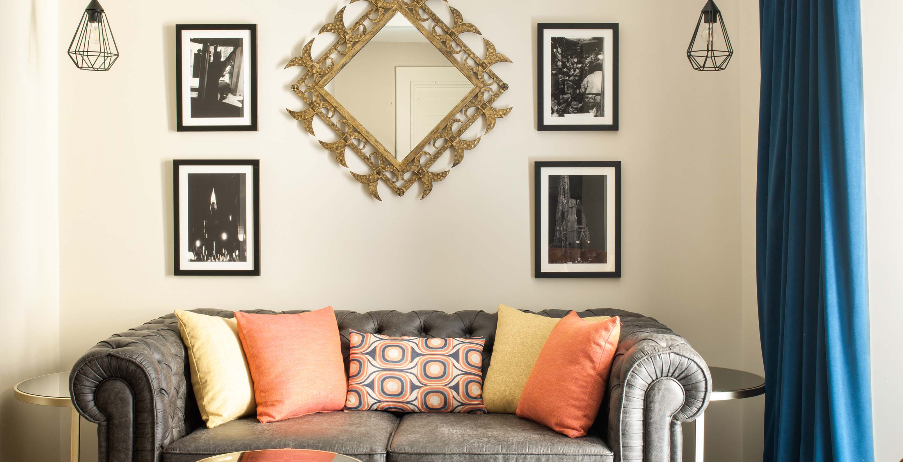 The Deluxe Grand Plaza Mayor at Pestana Collection Plaza Mayor has a gray two-seater sofa and paintings on the wall