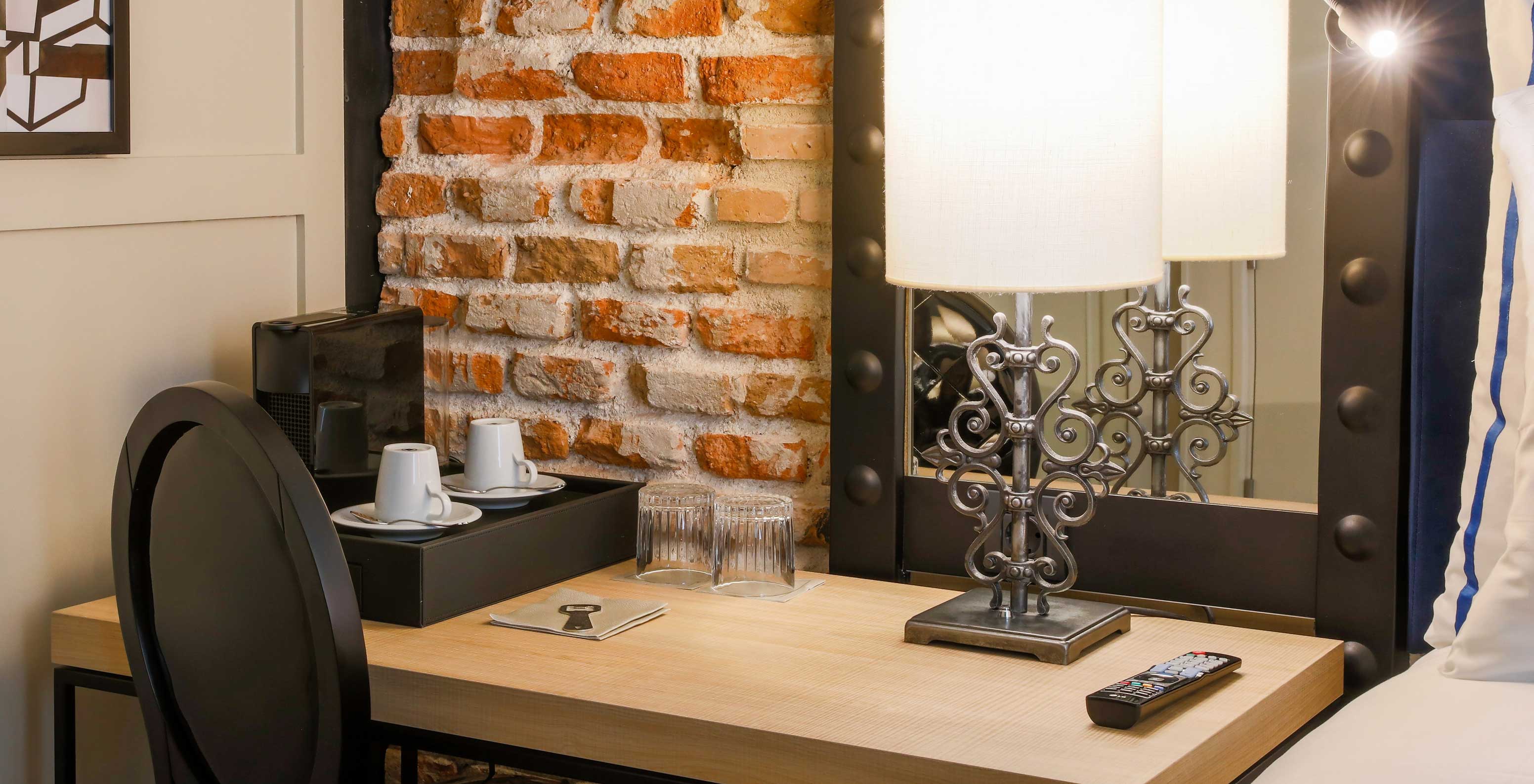 Superior Room at Pestana Collection Plaza Mayor has a desk, a chair, a mirror and a Nespresso coffee machine