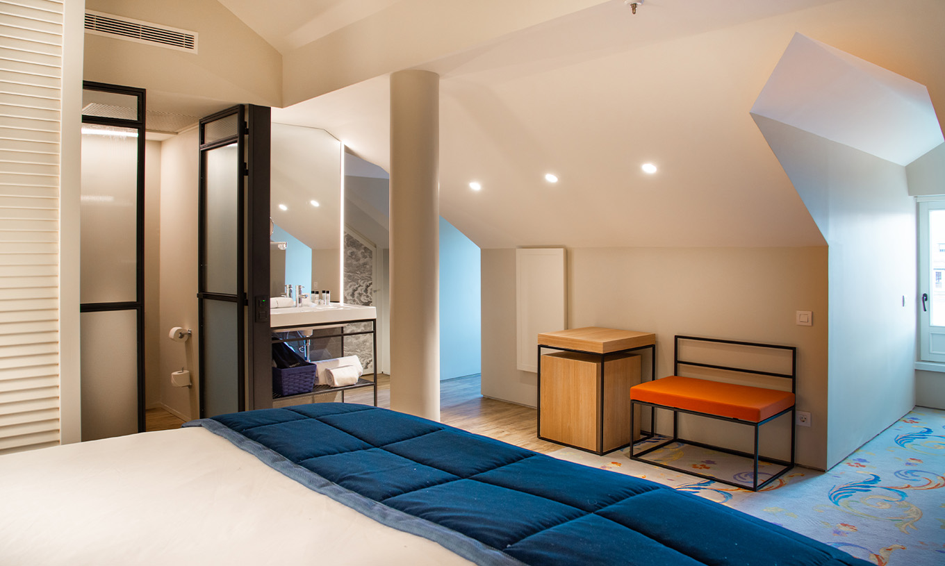 The Loft at Pestana Plaza Mayor Madrid has a double bed, a sink inside the room and a side table