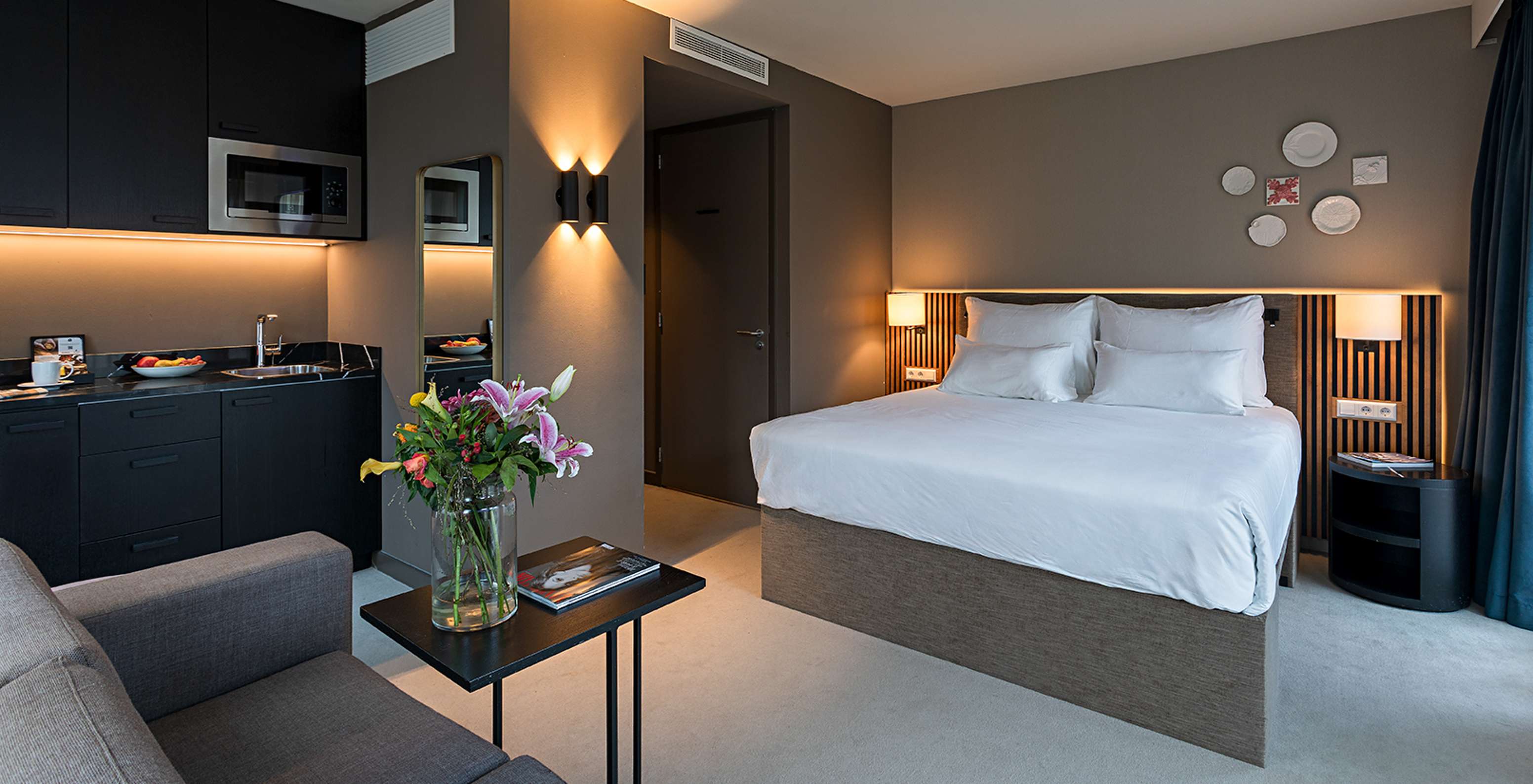 Classic Studio room at Pestana Amsterdam Riverside has a double bed, coffee table, and a kitchenette with microwave