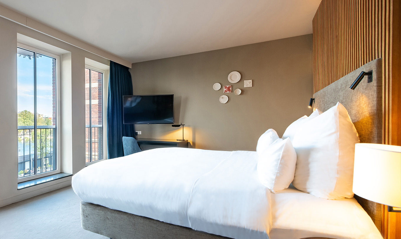 The Executive River View at Pestana Amsterdam Riverside has a double bed, reading lights, a TV and river view