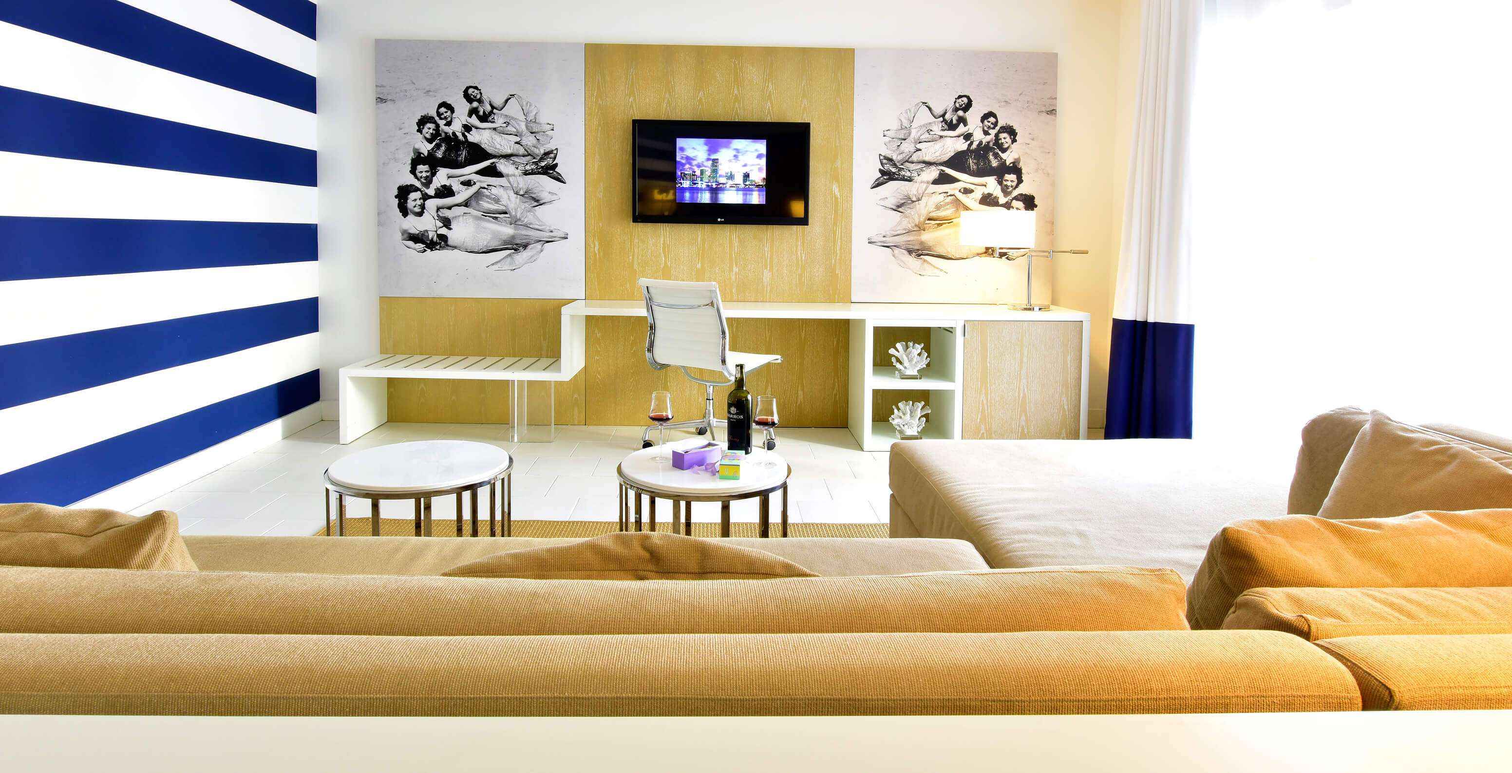 The Suite King with Balcony at Pestana Miami South Beach has a living room with a sofa with chaise longue, desk and TV
