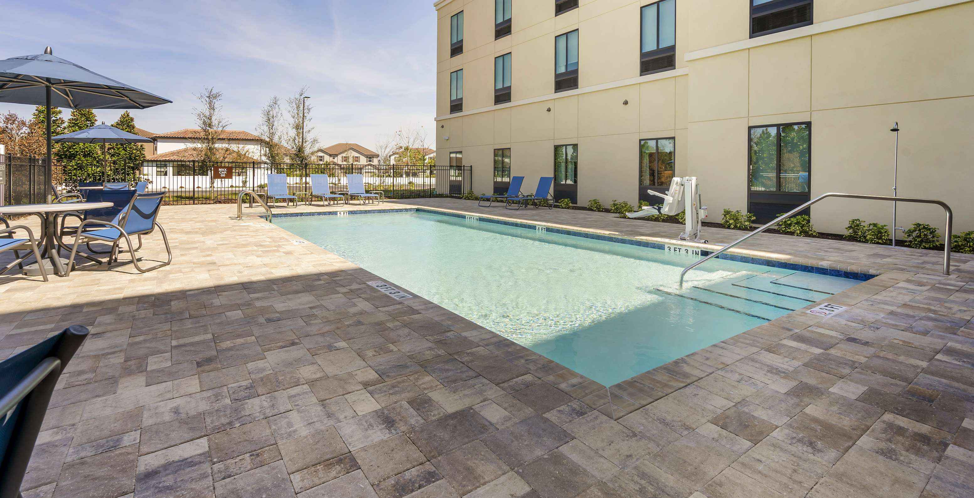 Pestana Orlando, a hotel near Disney, has an outdoor pool with loungers, umbrellas and chairs