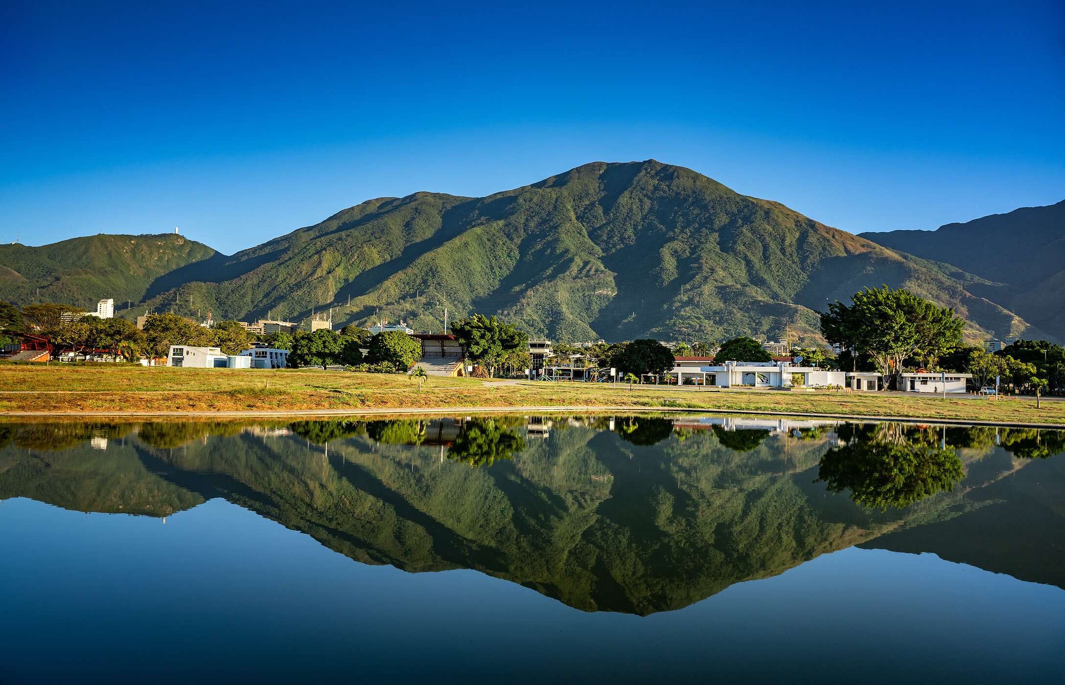 Panoramic view of an imposing mountain reflected in the calm waters of a lake in Caracas