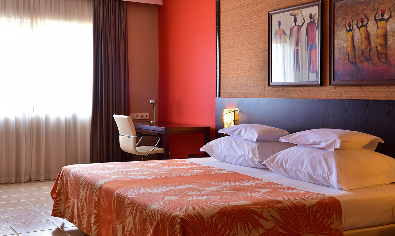 La Habitación Standard del Pestana Tropico cuenta con una cama de casal, escritorio con silla y mesa de cabeceira