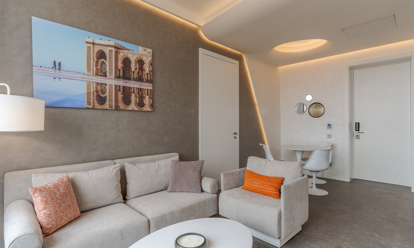 La Suite CR7 del Pestana CR7 Marrakech tiene una sala de estar con dos sofás, un cuadro y una mesa para comer