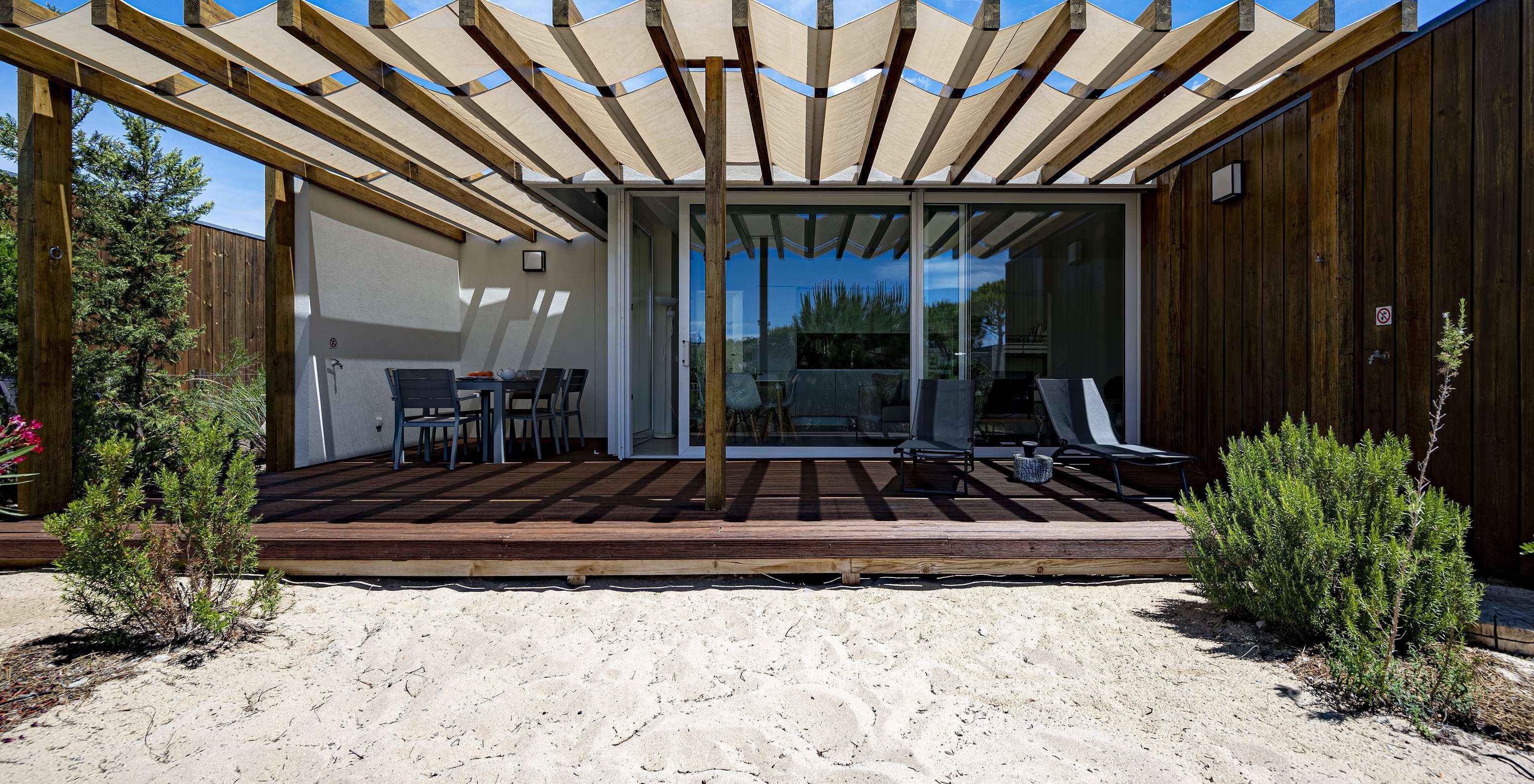 La Green Villa del Pestana Tróia Eco Resort tiene una terraza con dos tumbonas y una mesa con sillas