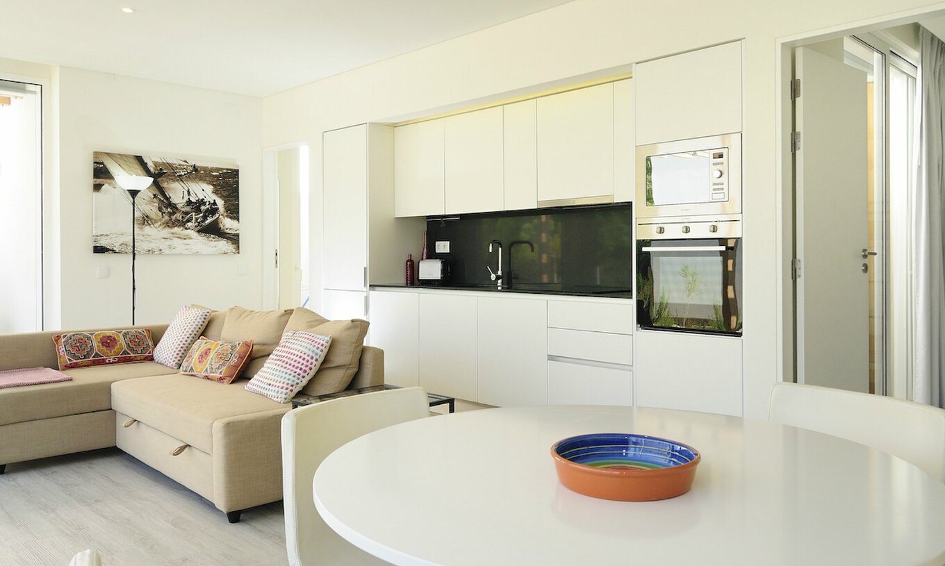 La Green Villa con Piscina Privada T3 del Pestana Tróia Eco Resort tiene una sala junta con la cocina, sofá y mesa para cenar