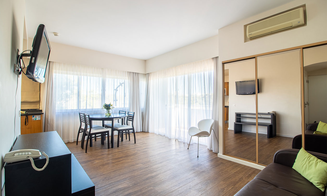 El Apartamento T1 Vista Jardín del Pestana Alvor Atlântico tiene sofá con televisión y armario con espejo