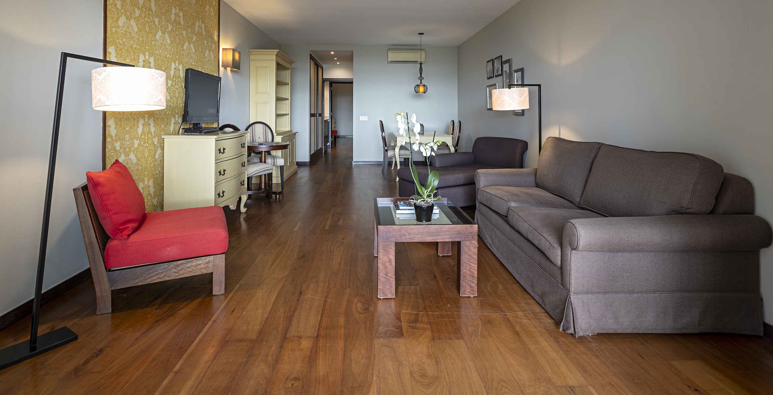 La Cliff Suite T2 en Pestana Alvor Praia tiene una sala de estar con dos sofás, papel pintado, una televisión y una mesa