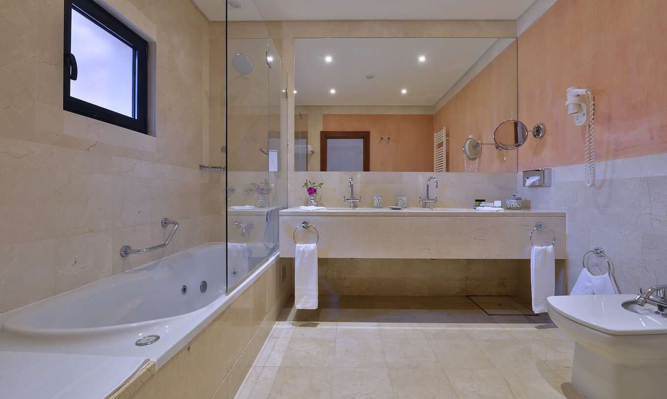 La Suite Vista Jardín Vila Sol del Pestana Vila Sol - Vilamoura tiene un baño con dos lavabos y bañera con ducha