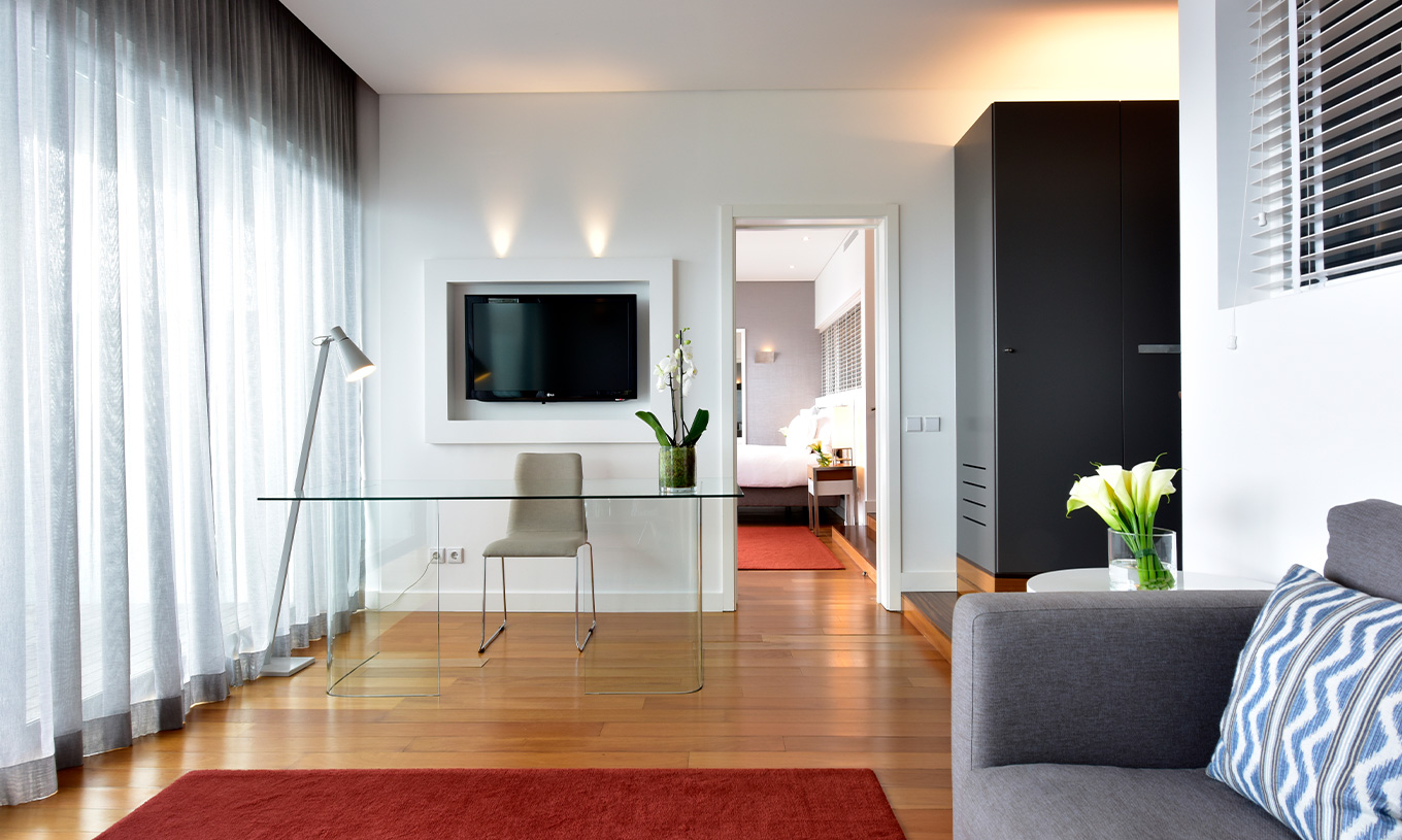 La Suite Vista Mar del Pestana Cidadela Cascais tiene una sala de estar con sofá, televisión, escritorio y mesa