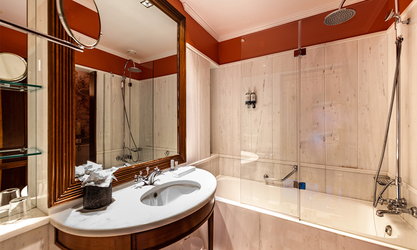 El Deluxe Garden del Pestana Palace Lisboa tiene un baño con bañera y lavabo de mármol y madera y espejo