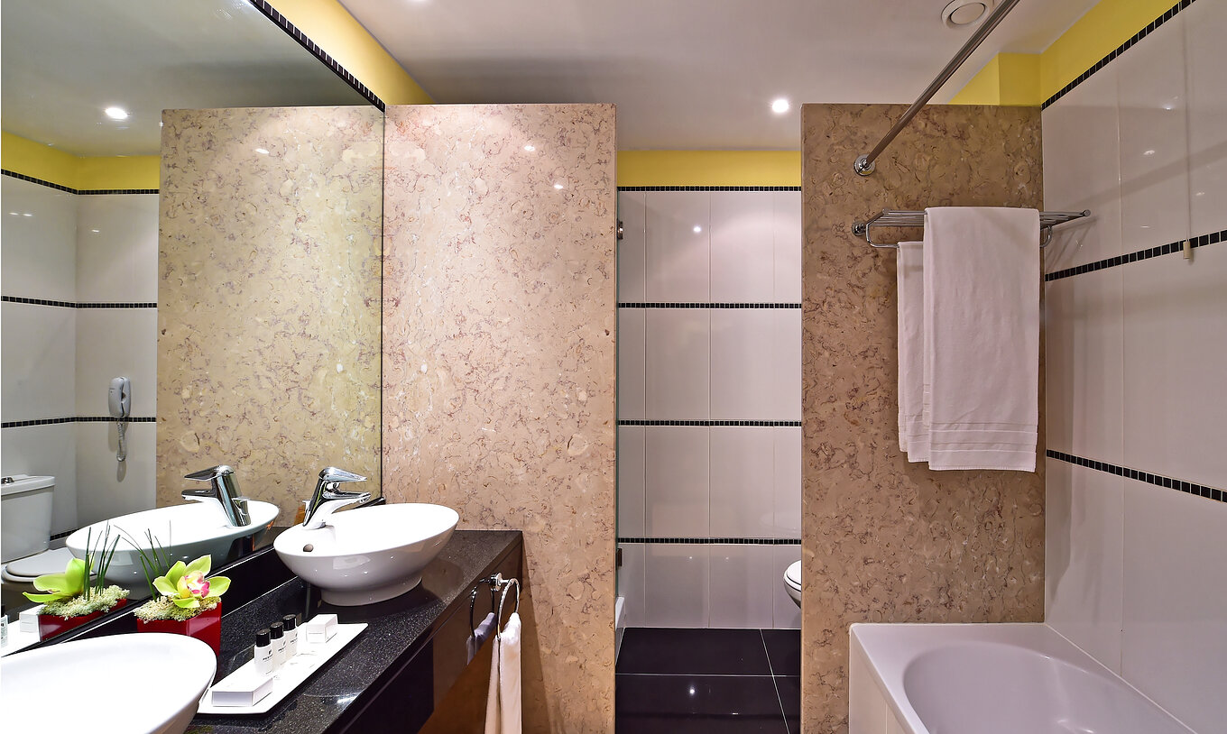 La Junior Suite del Pestana Sintra Golf tiene un baño con dos lavabos, espejo, amenities y bañera