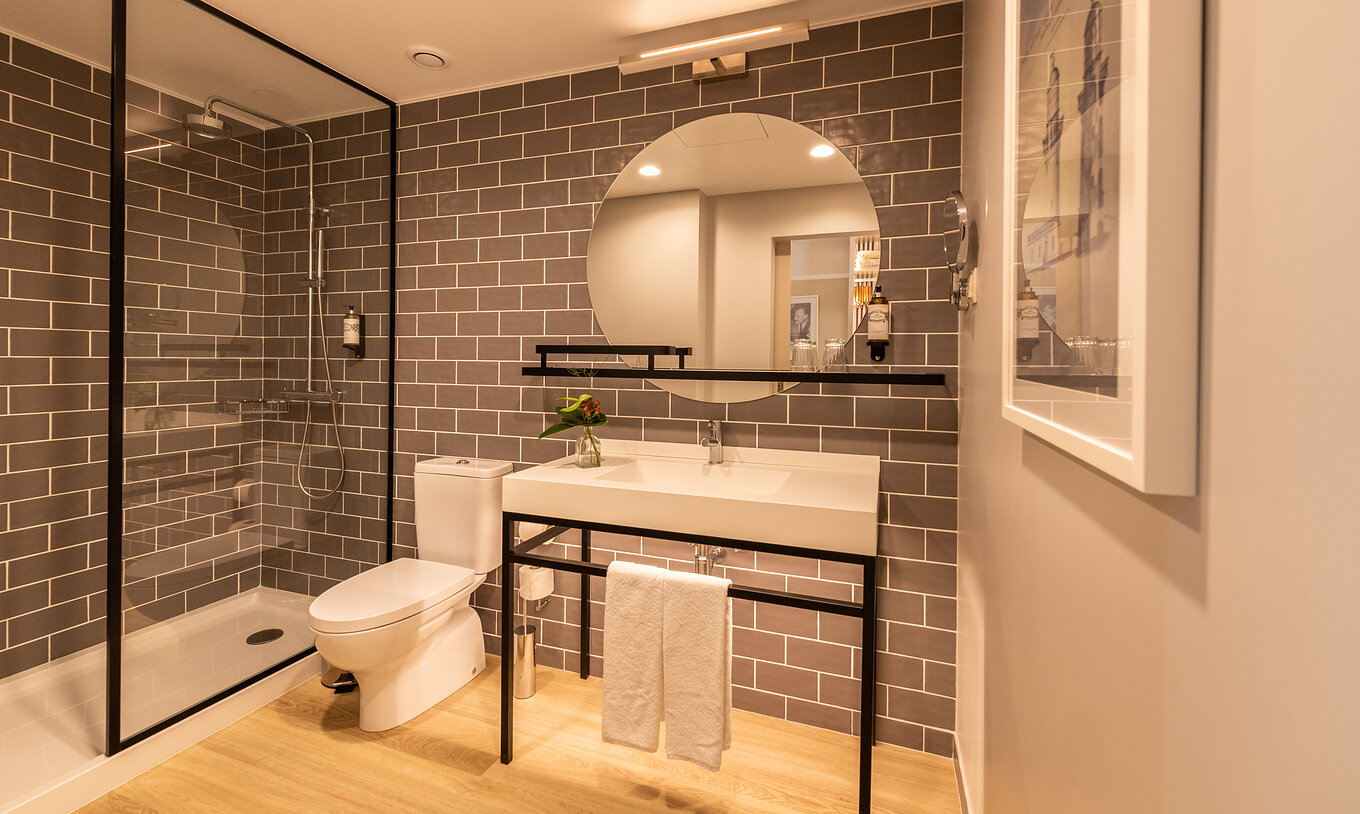 El Superior Familiar del Pestana Fisherman Village tiene un baño con ducha, inodoro y un espejo redondo