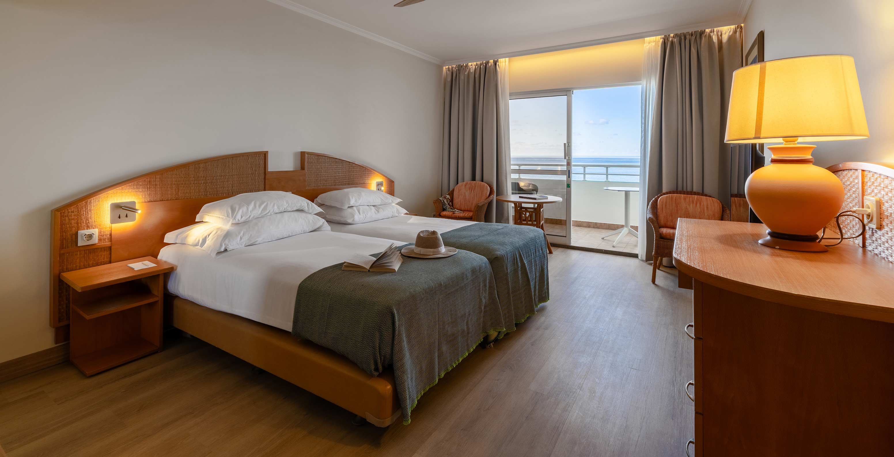 El Classic Sea View del Pestana Ocean Bay All Inclusive tiene una cama doble, mueble de TV, dos sillas y balcón con vistas