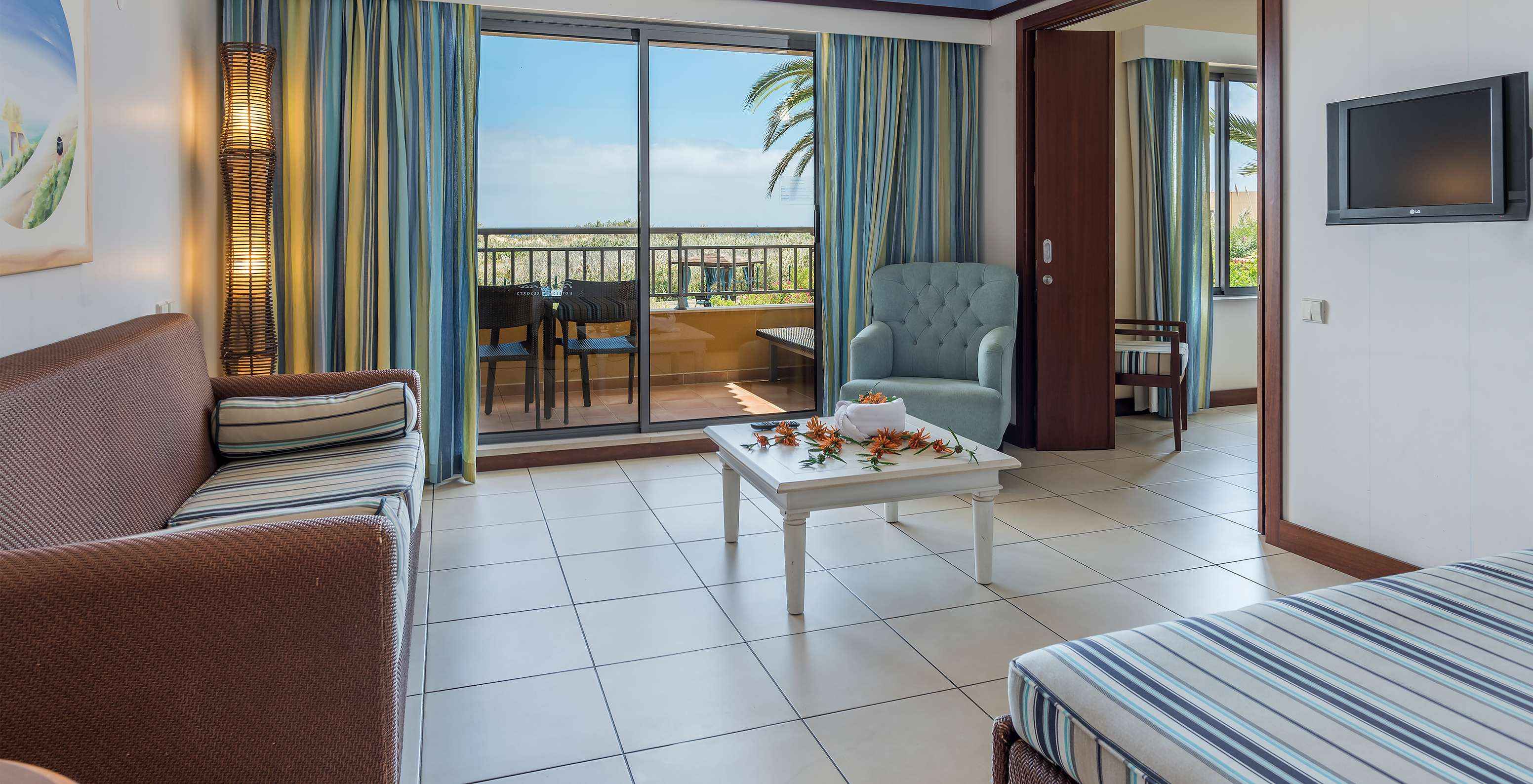 La Suite Apartamento T1 del Pestana Porto Santo All Inclusive tiene una sala con acceso al balcón, con vista al jardín