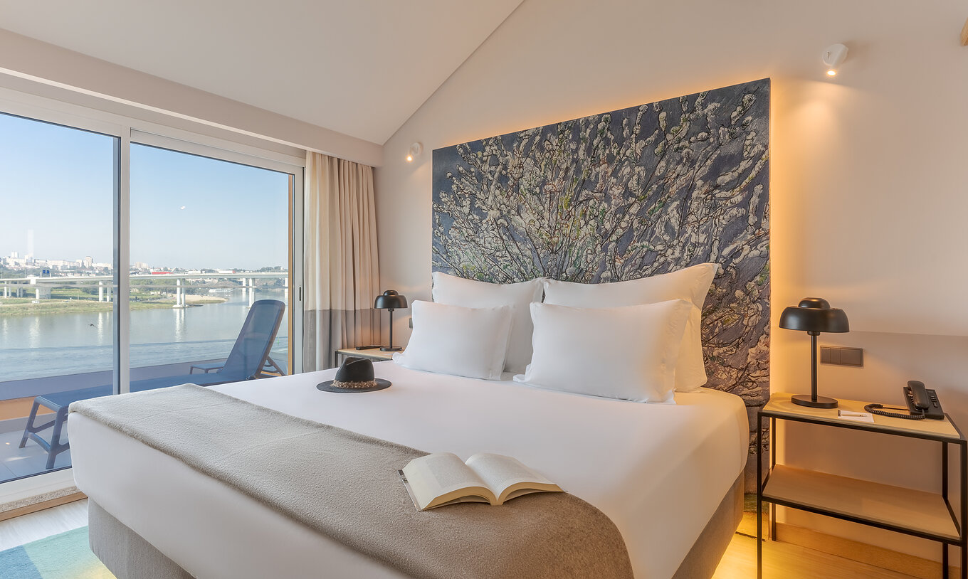 La Suite Douro del Pestana Douro Riverside cuenta con una cama de matrimonio con mesa de noche y terraza con vista al río