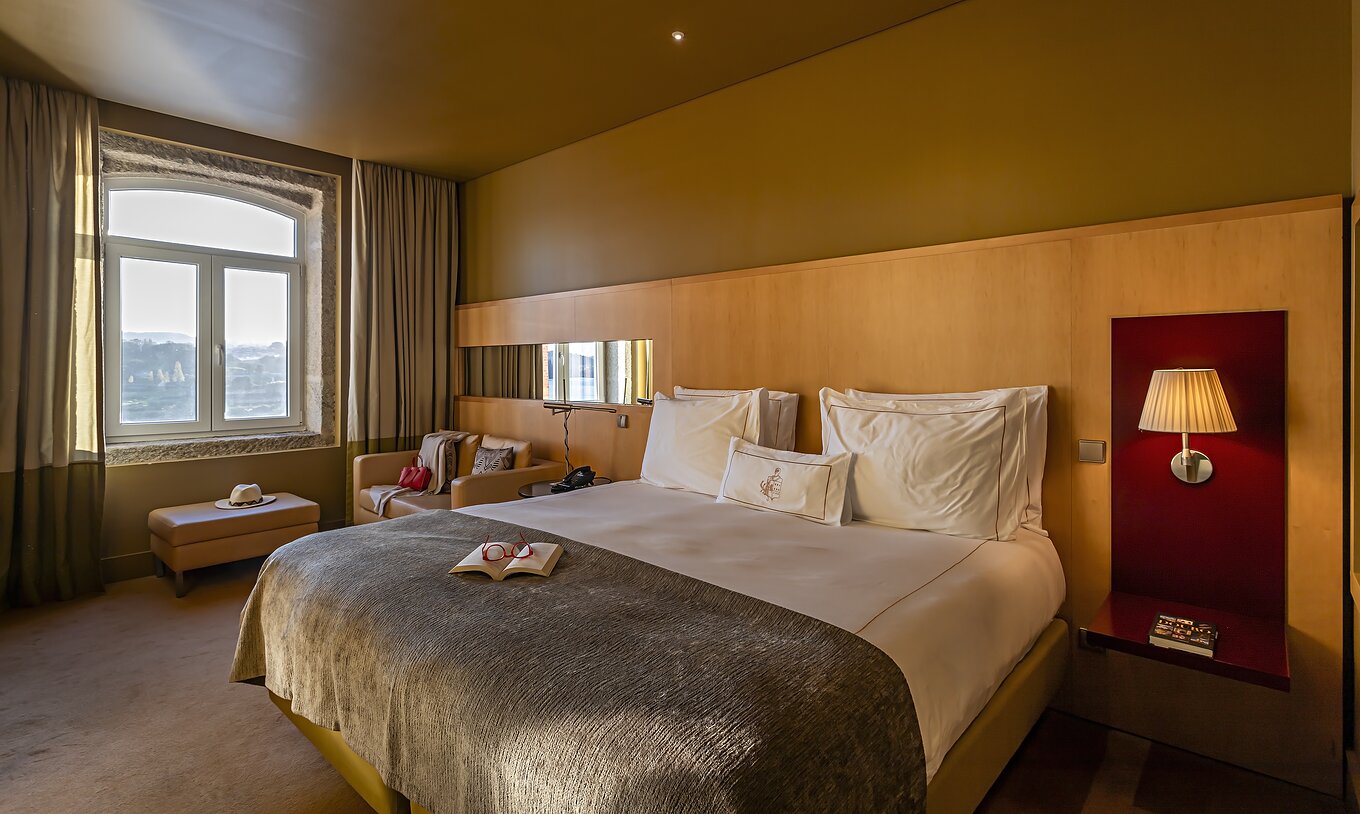 El Executive Superior tiene una cama doble, un sofá y un puff junto a la ventana