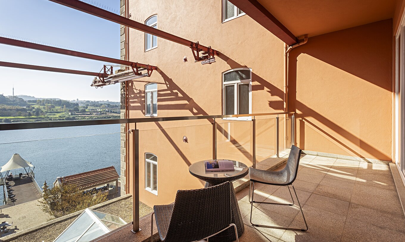 La Suite Balcony tiene un balcón con mesa, dos sillas y vista al río Duero