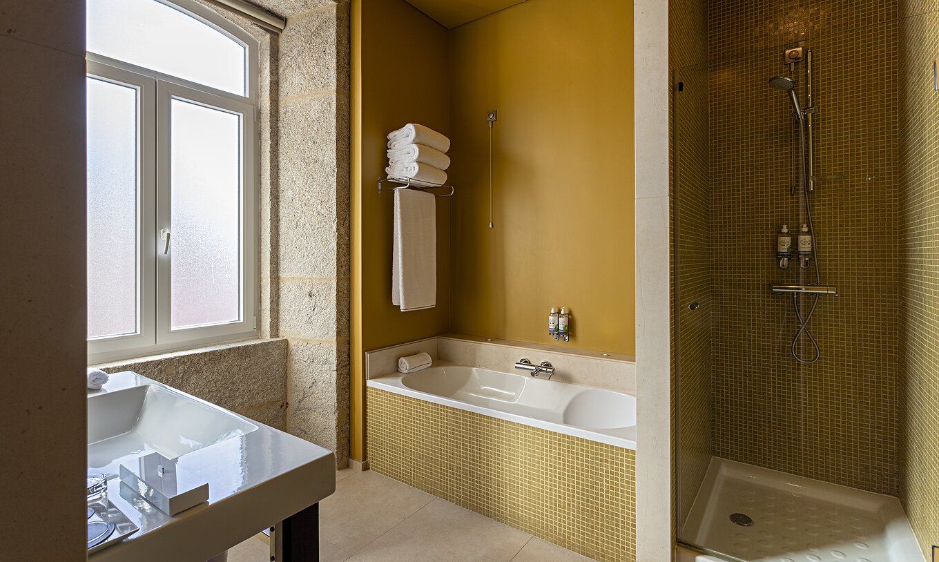 La Suite Nasoni tiene un baño con azulejos amarillos, bañera y zona de ducha