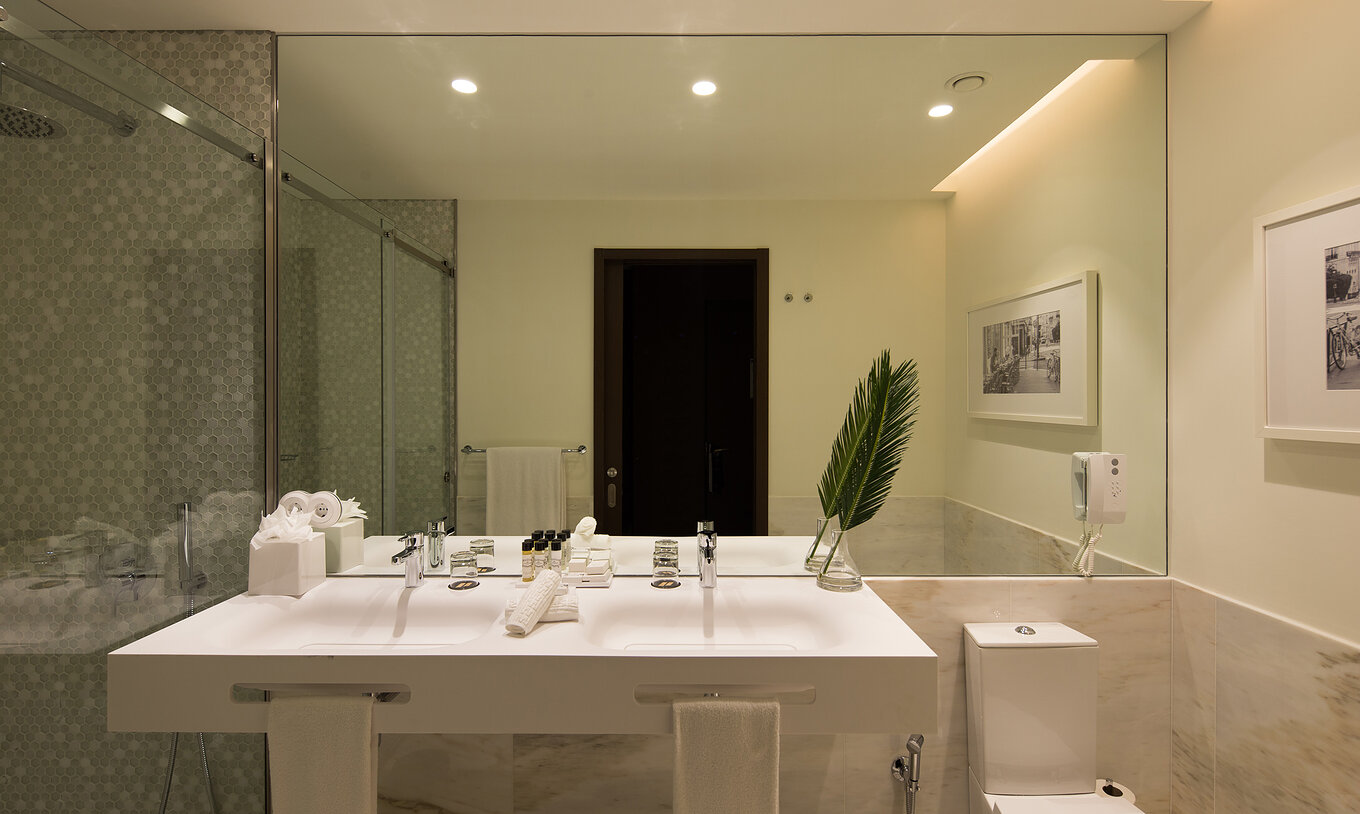 El Deluxe Executive del Pestana Porto - A Brasileira tiene un baño con dos lavabos y un inodoro con ducha
