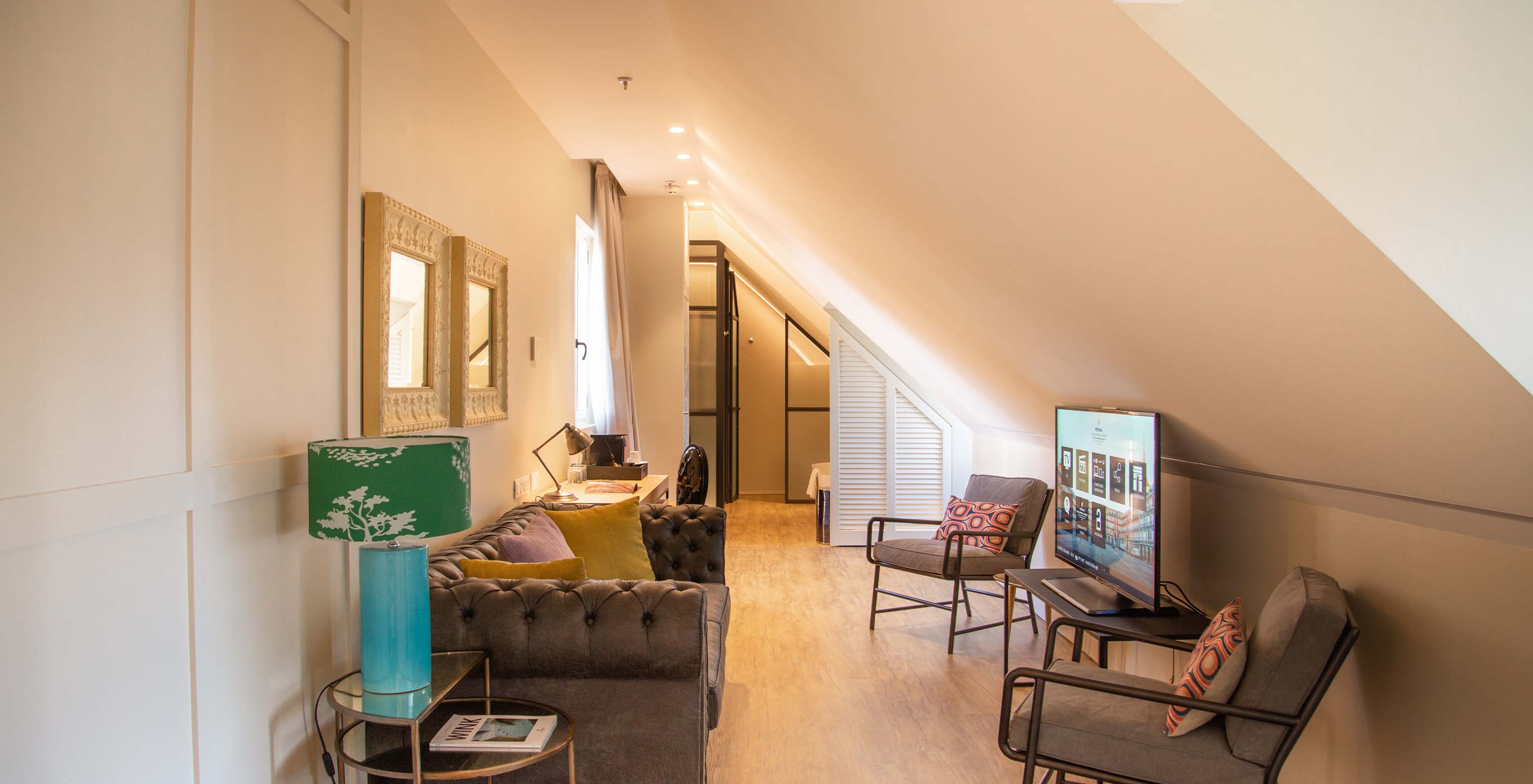 La Suite Plaza Mayor del Pestana Collection Plaza Mayor tiene una sala de estar con sofá, sillas, televisión y cuadros