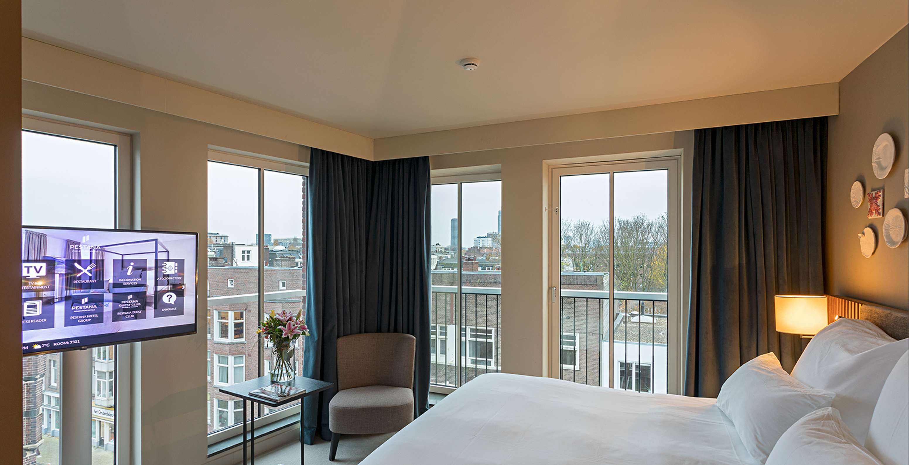 El cuarto Estudio Clásico del Pestana Amsterdam Riverside tiene una cama doble, una lámpara y ventanas con vista a la calle